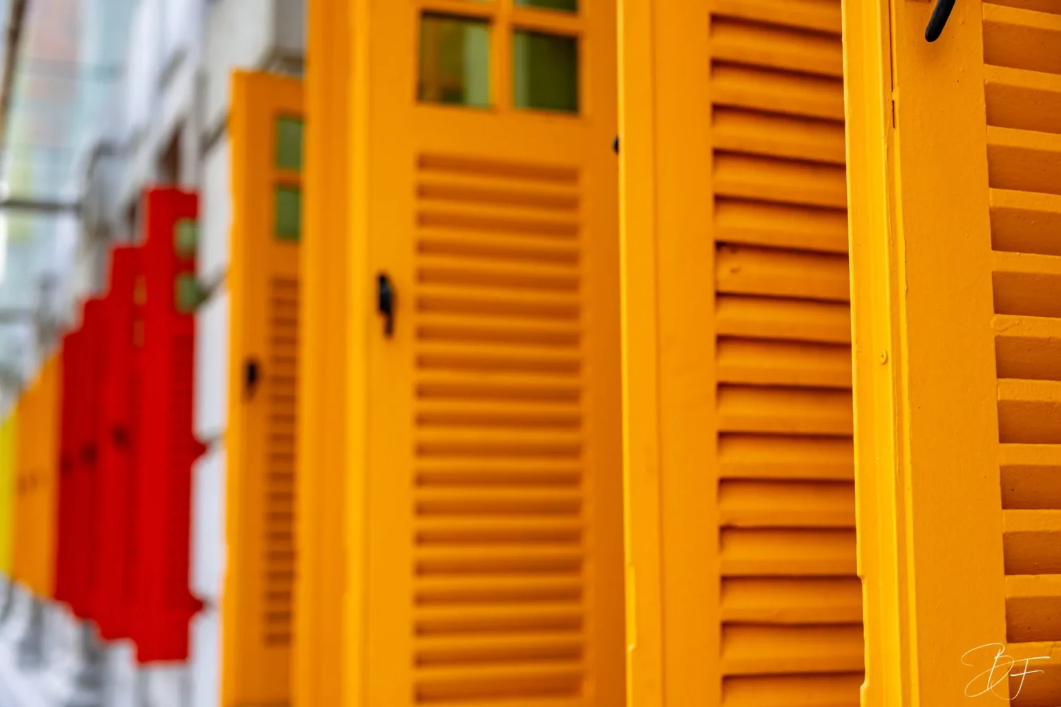 Orange and red shutters lined up on a facade